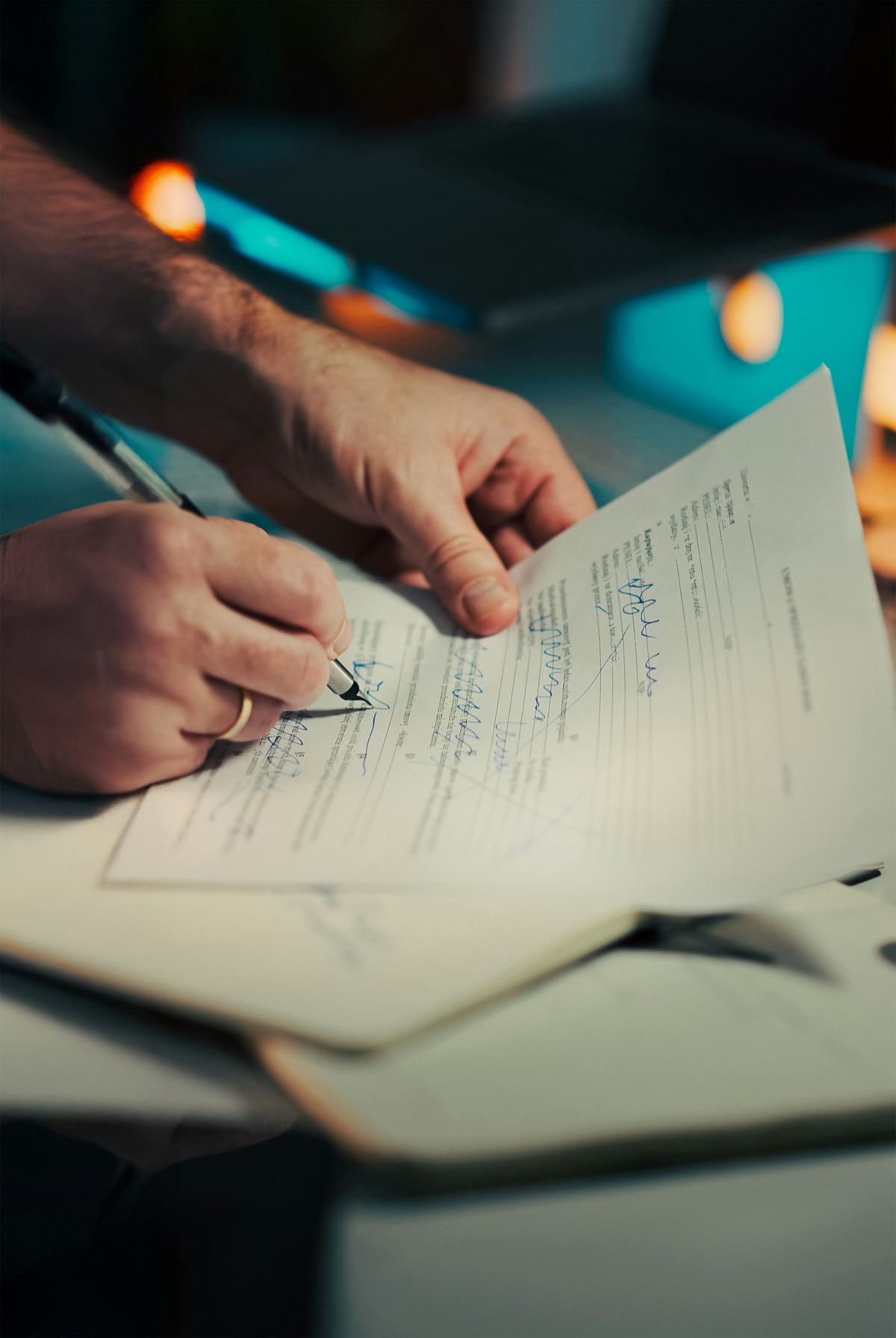 Hånd der udfylder og gennemgår et dokument med pen